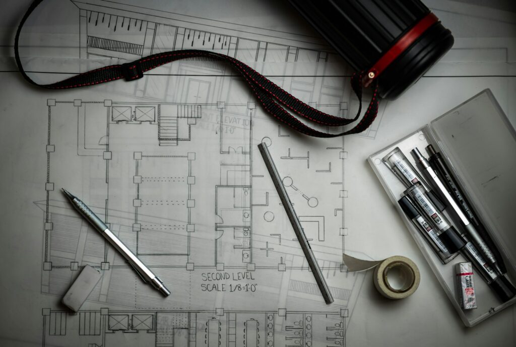 Architectural blueprints with drafting pencils and a metal ruler
