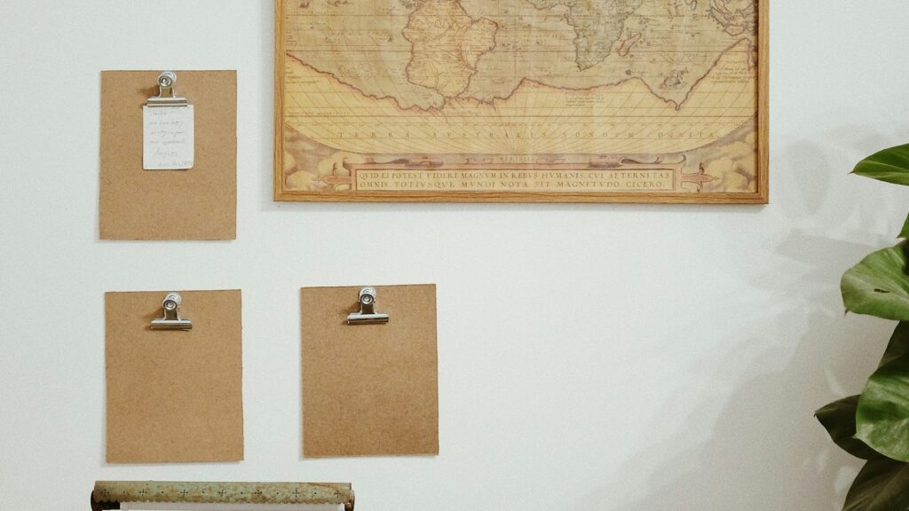 A wall-mounted map above a desk with blank cards clipped beside it