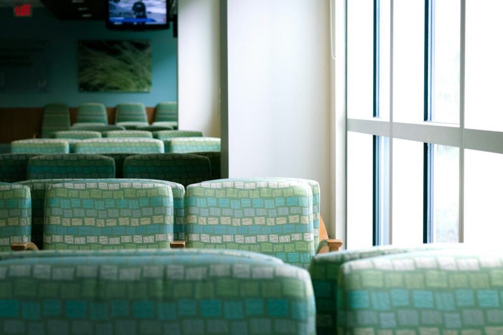 Clinic waiting room with a row of green and white chairs