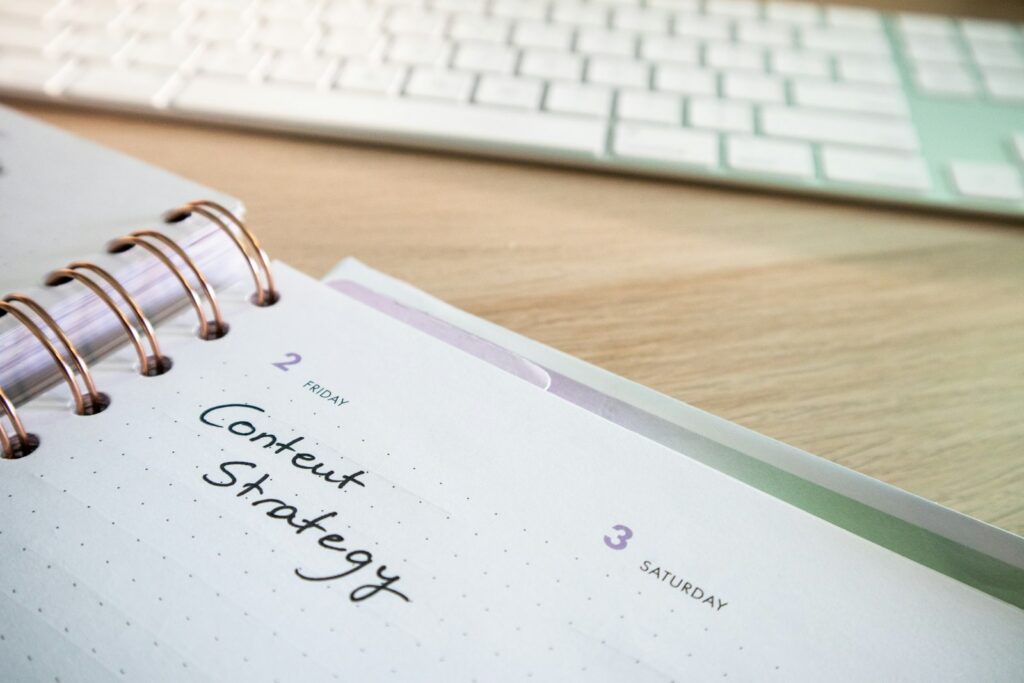 An open planner with a content strategy page beside a keyboard