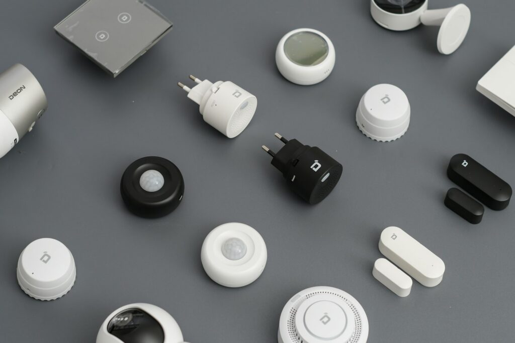 A flat lay of small connected home devices on a grey surface